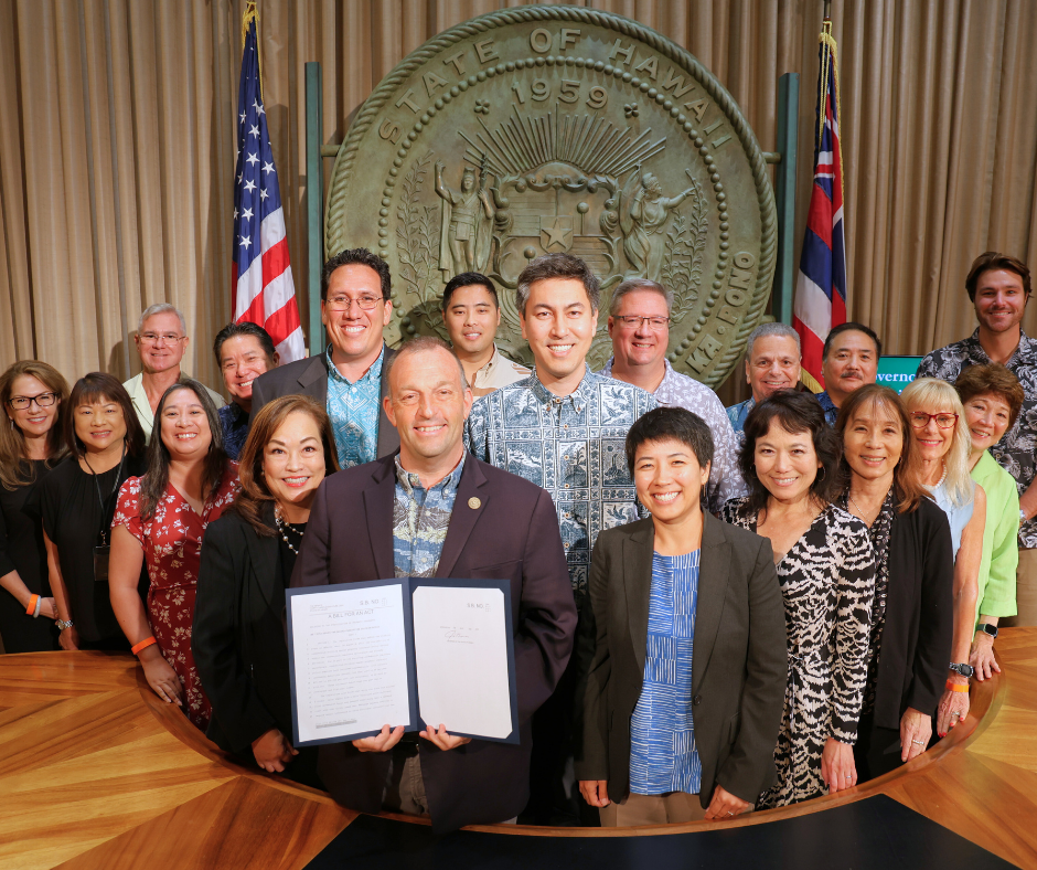 Governor Green holding signed bill surrounded by those involved in property insurance market stabilization