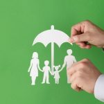 paper cutouts of a family under an umbrella